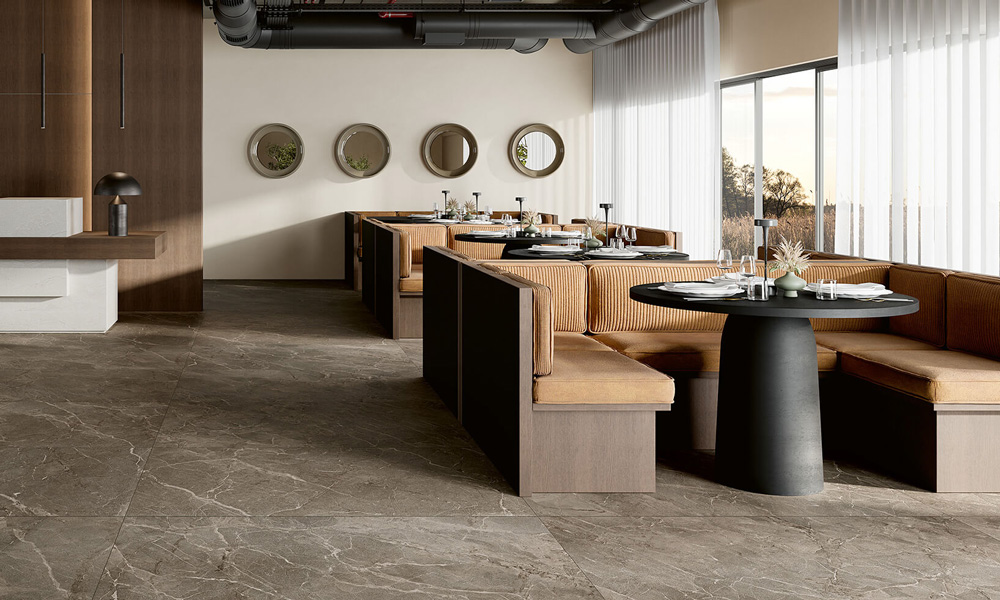 Restaurant mit Sitznischen und großformatigen Bodenfliesen in brauner Marmoroptik