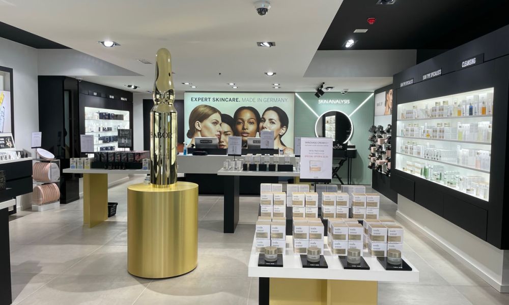 BABOR-Geschäft mit hellgrauem Großformat-Fliesenboden, Produktregalen und Wandbild „Expert Skincare. Made in Germany“