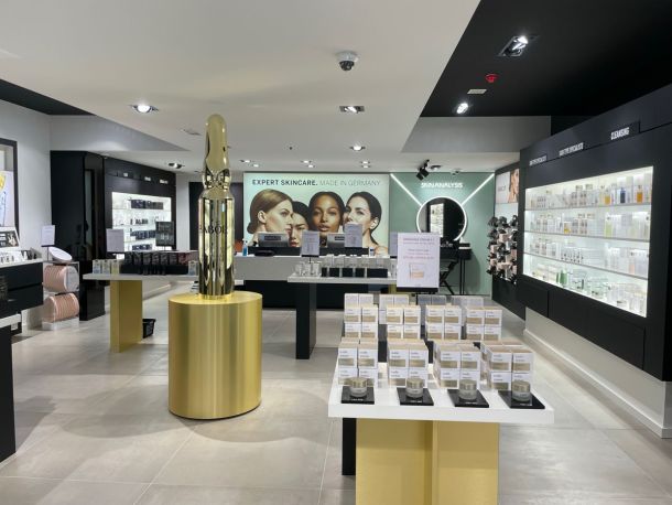 BABOR-Geschäft mit hellgrauem Großformat-Fliesenboden, Produktregalen und Wandbild „Expert Skincare. Made in Germany“